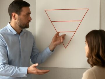 News reporter organizing an inverted pyramid story beside a photojournalist's camera